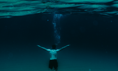 a swimmer deep underwater representing click depth