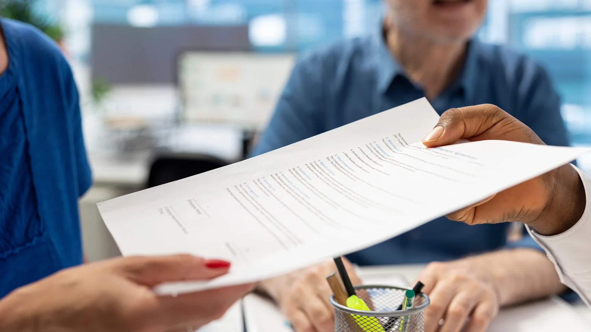 Insurance papers being handed to a woman by a man.