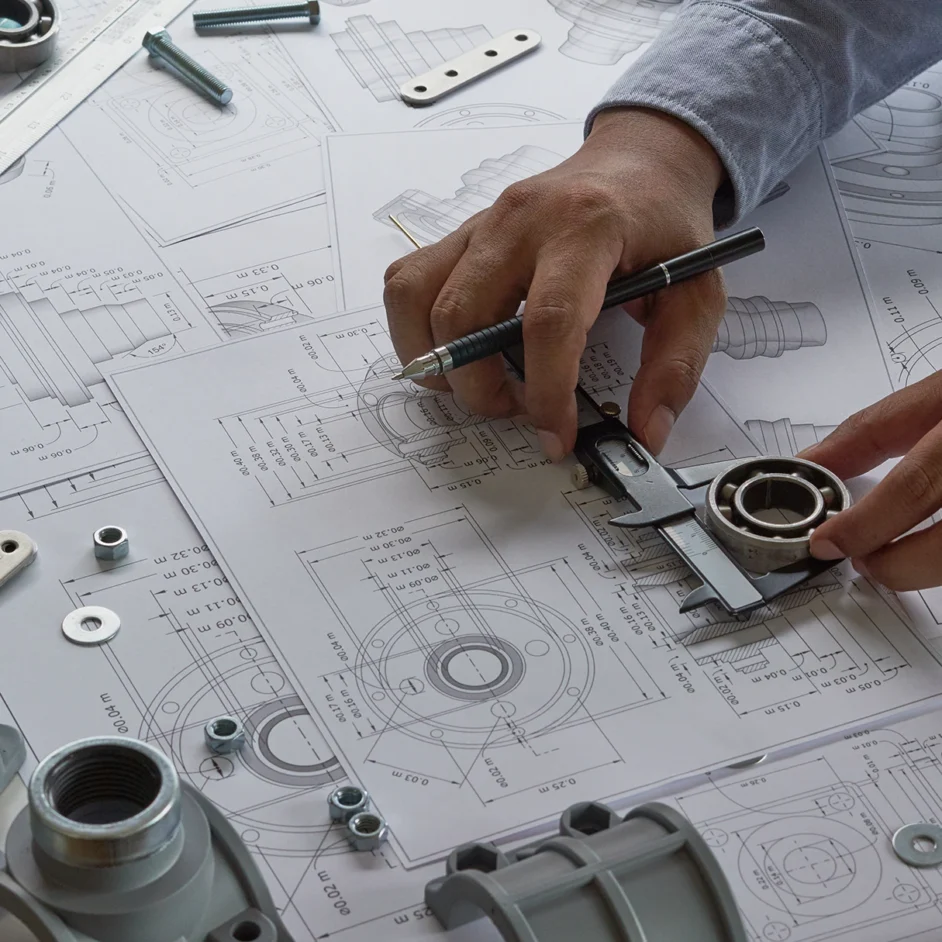A person examines a blueprint while holding a wrench, focused on a mechanical project.