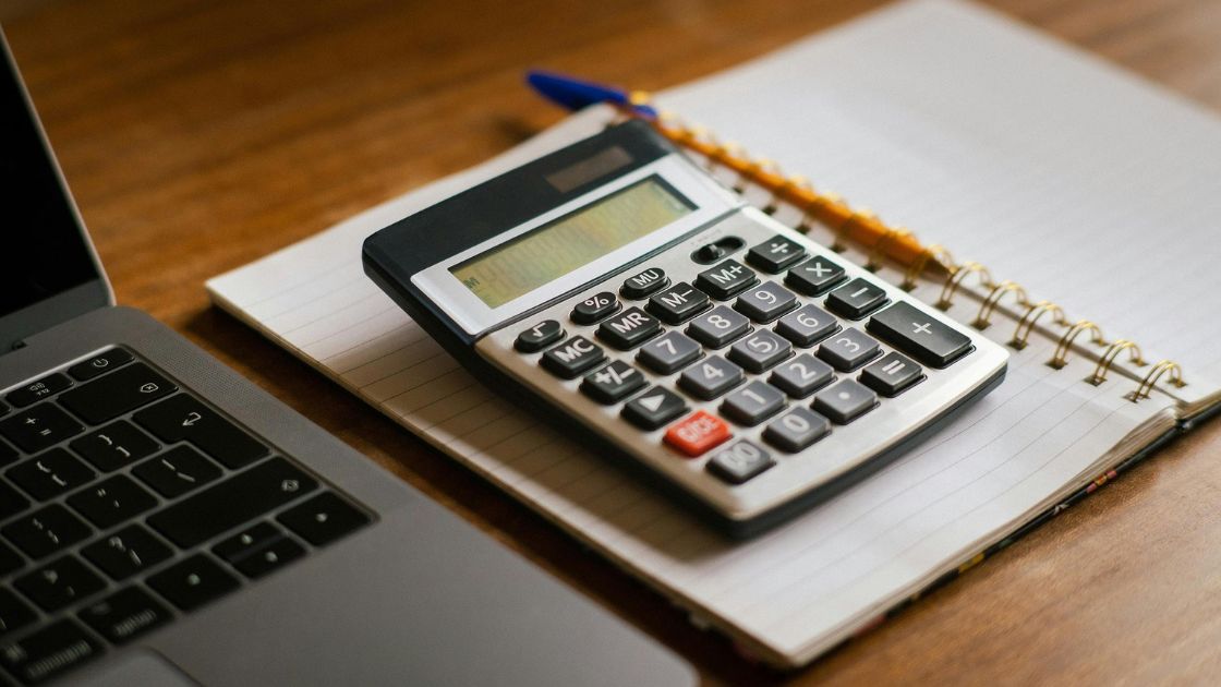 Laptop, notepage, calculator on a desk