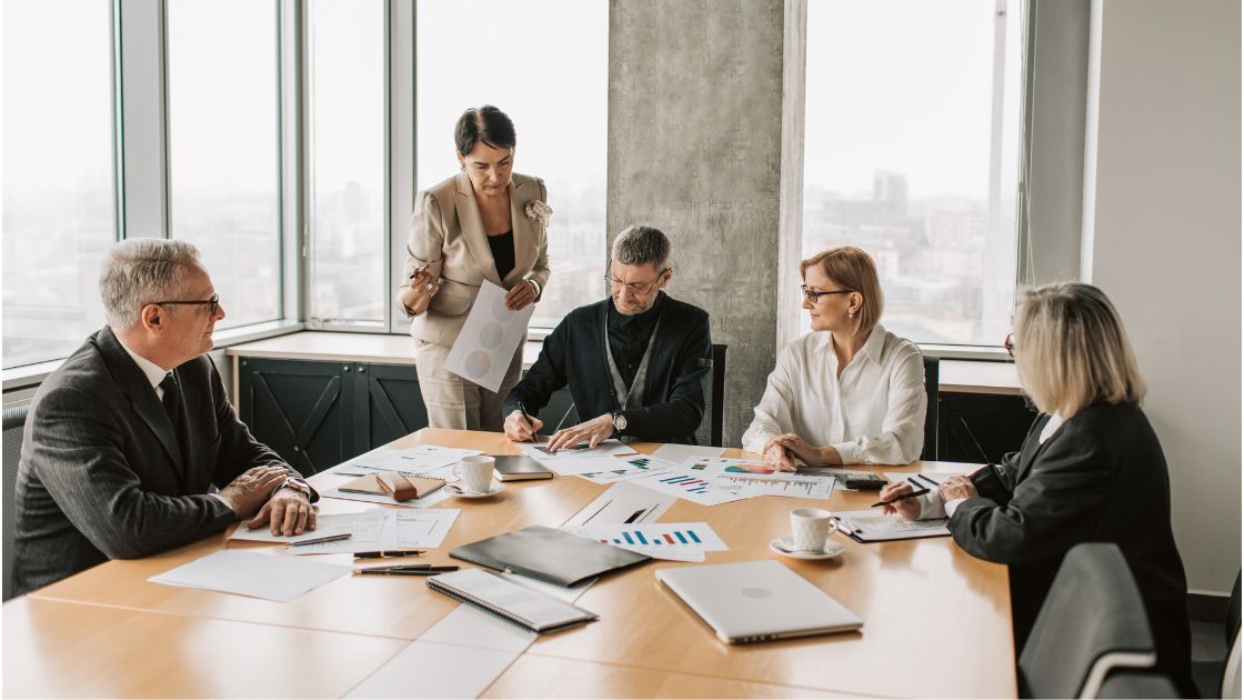 Modern professionals in meeting room signing and reviewing documents